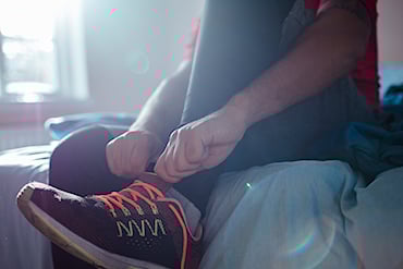 Person som tar på sig gympaskor