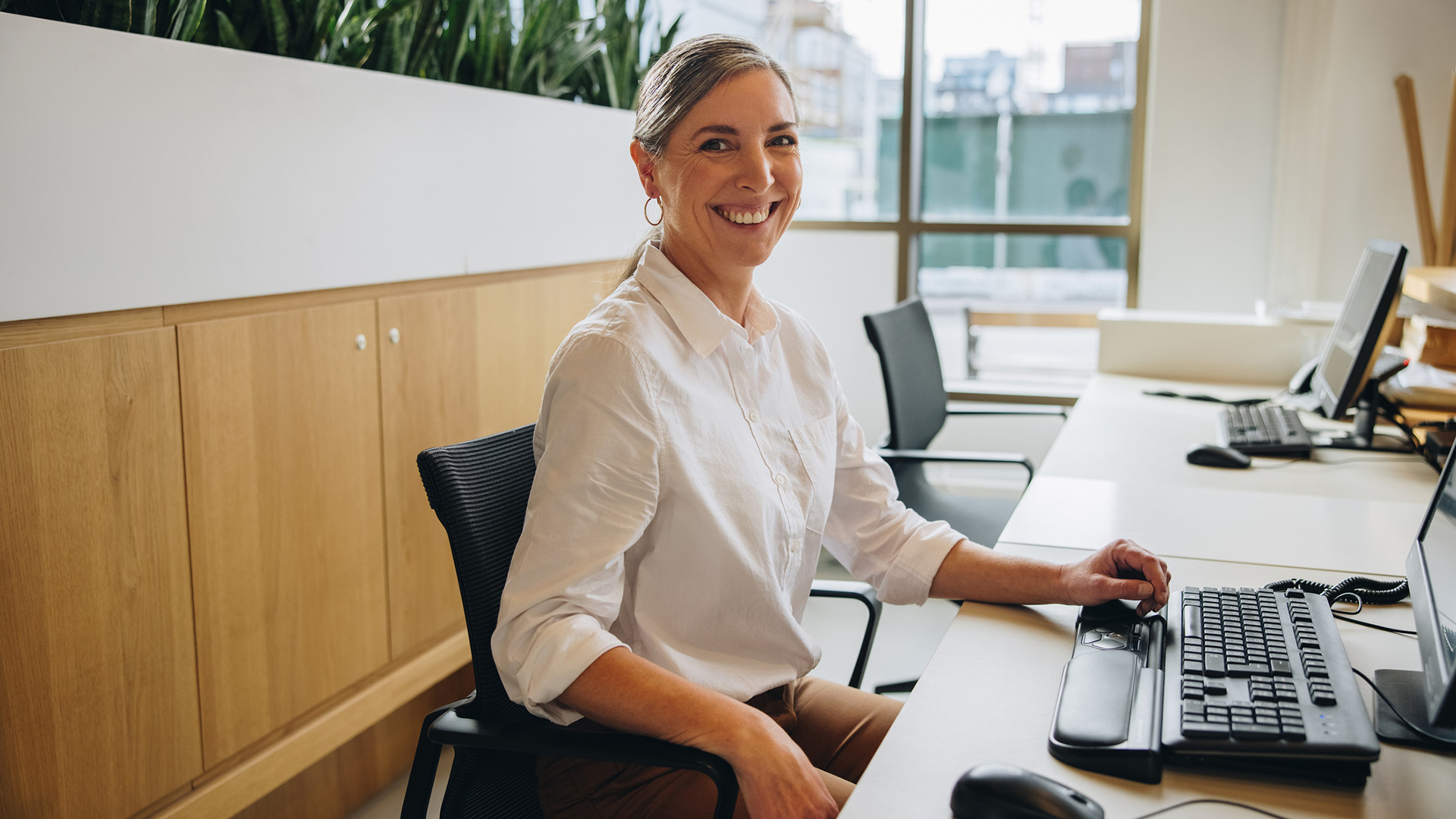 Kvinna vid sitt skrivbord på kontoret